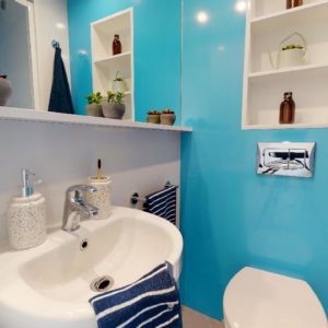 The blue walls of the bathroom create a calming atmosphere.